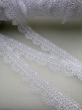 Delicate white nylon lace on fine netting with floral pattern and decorative edging